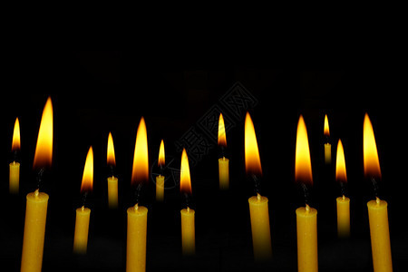 黄蜡烛在抽象的黑暗背景上图片