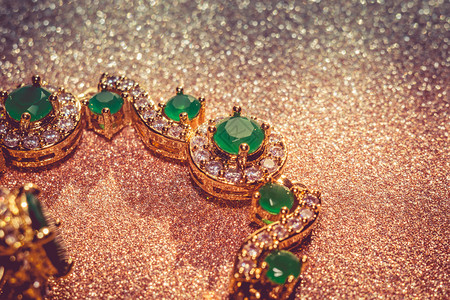 珠宝钻石优雅的女首饰金手镯珍贵的绿宝石背景