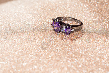 黑色时装金戒指紫的铁环在闪发光的背景上图片