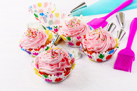 带粉红色奶油卷和甜针筒的蛋糕带粉红色奶油的生日蛋糕土制的装饰纸杯蛋糕图片