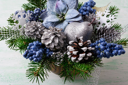 圣诞节背景蓝色丝绸薄饼和闪亮的浆果人造圣诞花与松锥和树枝安排节日装饰图片