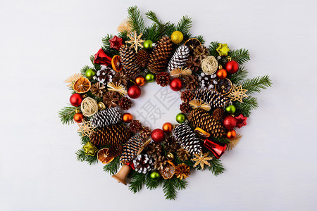 圣诞花环有圆枝松果和叮当铃圣诞节背景有生锈的装饰品和干橙片图片