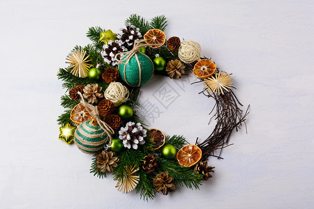 圣诞花环上面有雪的松果和古老装饰品圣诞节装饰上面有卷叶绿球自制的麻绳和草星图片