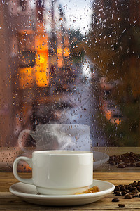 清晨一杯咖啡在雨天透过窗户观望图片