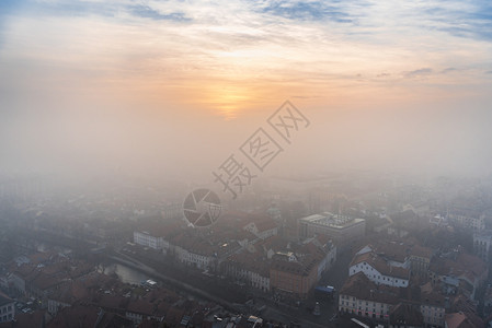 在十二月的寒冷天的冬日落穿过洛维尼亚首府卢布尔雅那市的雾空中观赏图片