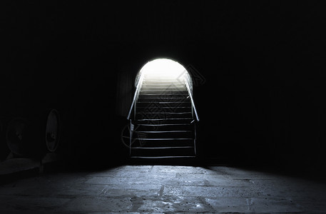 中世纪地下室完全黑暗出口有强光背景图片