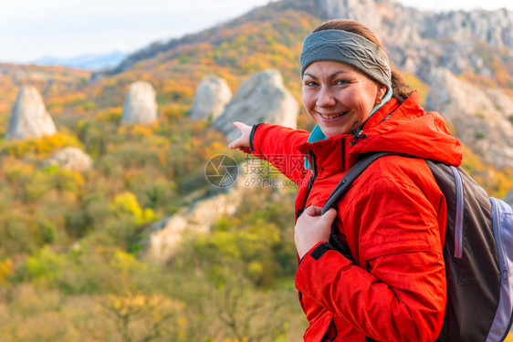 一个旅行者指向悬崖秋山的肖像图片