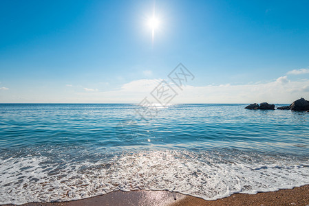 海景是明亮的中日阳光在清澈的海水之上望着地平线图片