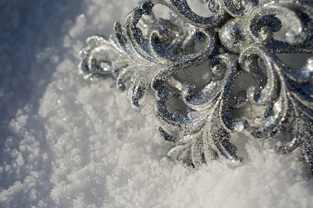 装饰银雪花闪发光亮于新鲜的白雪上图片