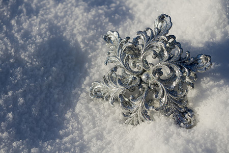 装饰银雪花闪发光亮于新鲜的白雪上图片