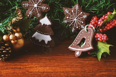 圣诞饼干在节日树枝下挂木制桌子上图片