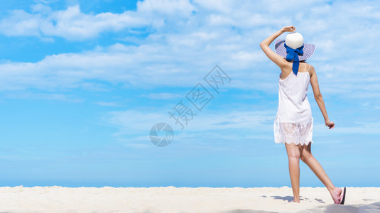 美丽的女人在海滩上走着蓝色的天空快乐暑假添加文字信息的照片设计艺术工作的背景图片