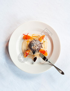 巧克力甜点巧克力味熔岩蛋糕香草酱柑橘白盘和叉子的金叶图片
