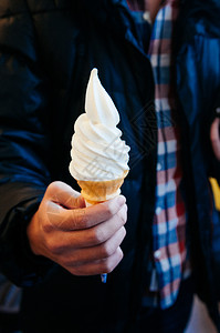 救身圈近身的柔软提供牛奶香草冰淇淋甜圈在男人的手背景