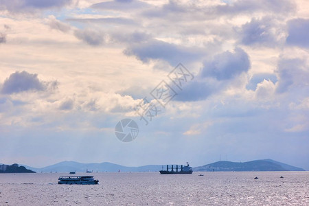 海景宽广船过天空美丽云彩灰白船经过岛湾海图片