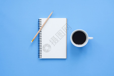 办公桌工作空间平面工作空间的顶层视图模型蓝面纸背景的咖啡杯蓝色面背景空间概念图片