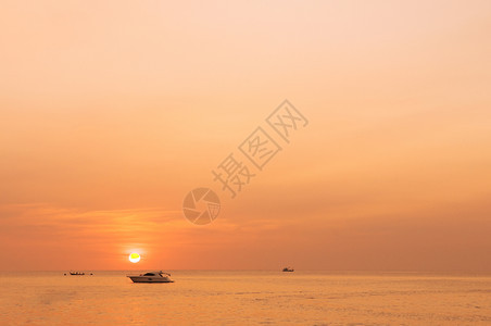 金色的日落与月光般的船停在海边的普吉岛图片