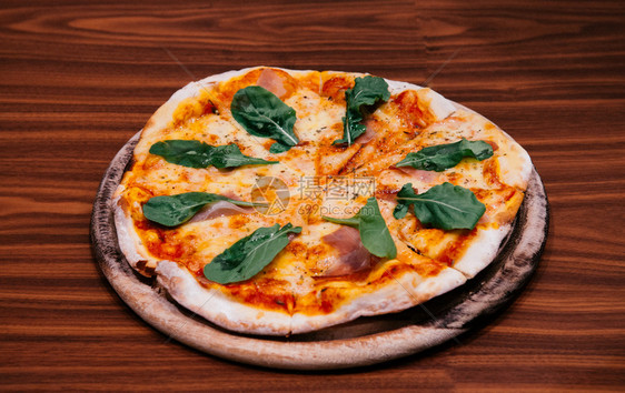 意大利马格赫里塔比萨饼配有帕玛火腿和木盘桌子上的巴西尔图片