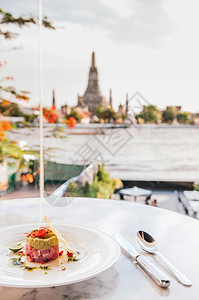 金鱼塔雷在餐馆桌上的白板配有avocdstbi和石灰有Watrun寺庙和ChaoJurw河风景泰国Bangko图片