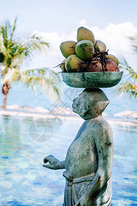 2013年月日泰国萨穆伊石雕猴子在热带泰岛度假胜地游泳池上头顶着椰子图片