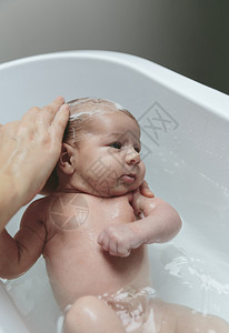 在浴缸里与母亲一起洗头发与母亲一起洗头发的新生儿在浴缸里与母亲一起洗头发的新生儿图片