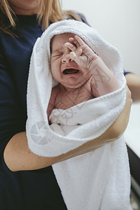 新生儿女婴在母亲带她走出浴缸时哭泣图片