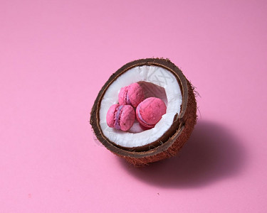 粉红背景的色迷你蛋饼最小的创造概念椰子背景的粉红一半和背景的蛋饼图片