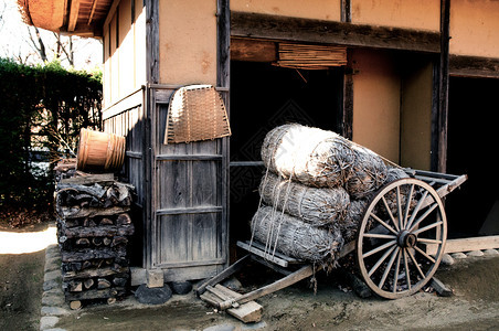 装满货物的旧式马车停放在小巷老屋前图片