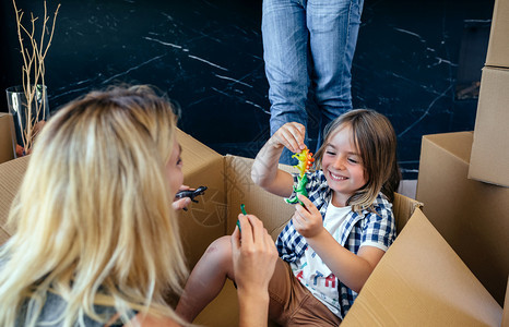 母亲和儿子玩具坐在一个移动的盒子里母亲和儿玩一个移动的盒子里图片