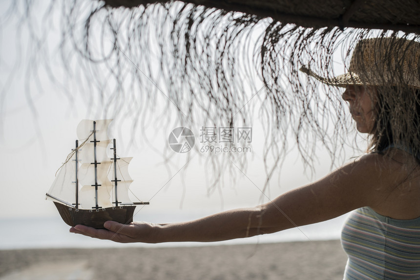 在沙滩上戴帽子的女人图片