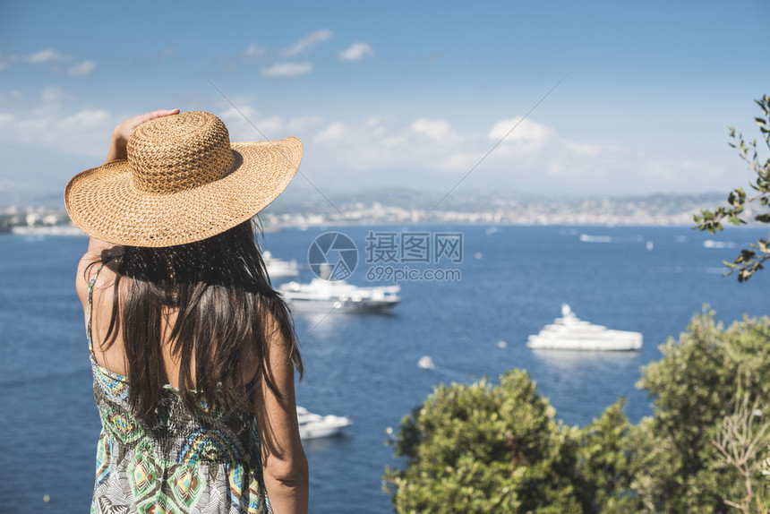 穿着暑假帽子看游艇的女人图片