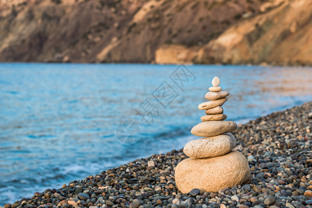 相光平衡概念在一个小石头海滩上一栋白宝石金字塔的紧闭图片