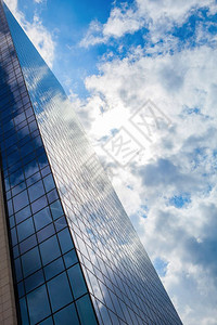 高楼玻璃大的云层反射与天空相对现代的烟雾玻璃办公室与蓝色的云层相对背景图片