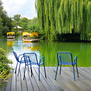 一座木制码头是市公园湖边的平台舒适座位区图片