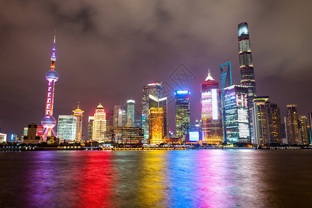 夜里照亮了上海市的天线水面有彩色的灯光反射着水面图片