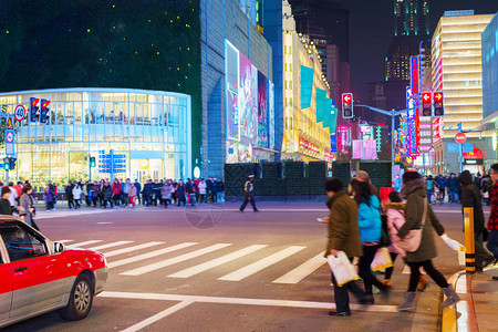 街上购物的十字路口上人们晚闪耀着的灯光图片