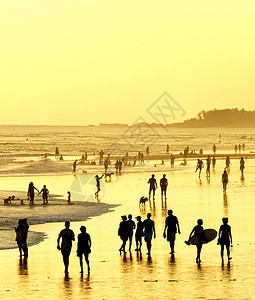 日落时在海滨上行走的人图片