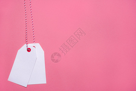 粉红色纸面背景销售概念或黑色周五上挂着两个空白标签的最小风格图像图片