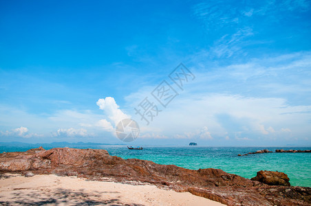 夏季有水晶清和船的岩石海滩图片