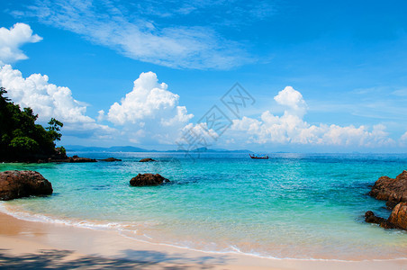 夏季有水晶清和船的岩石海滩图片