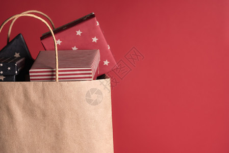 纸袋里装满了包裹着黑纸和红的礼物色背景的图片