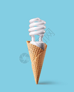 蓝底的冰淇淋锥体中紧凑型荧光灯泡由节能制成的冰淇淋创新概念冰淇淋锥体中的紧凑型荧光灯泡图片
