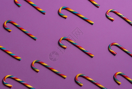以彩虹色甘蔗展示在紫色纸背景上的一个图案图片