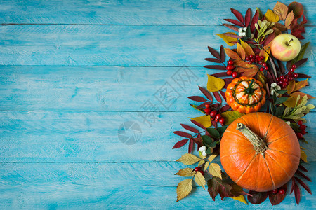 感谢或秋天的问候背景苹果红浆树叶和南瓜的边界在生锈蓝色木制桌子上复空间图片
