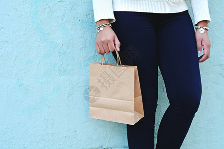 女手持户外购物袋女消费主义和生活方式概念图片