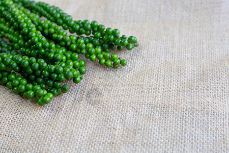 麻布背景上的新绿色胡椒玉米图片