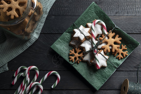 圣诞糖果姜饼干和条纹甘蔗糖放在绿色纸巾上的图片