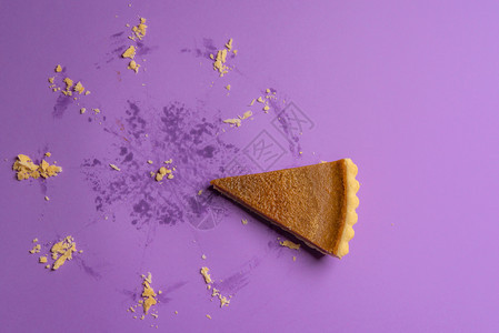 美味的南瓜派切片和整个馅饼的可见痕迹紫色背景最起码的形象美味节日甜点背景图片