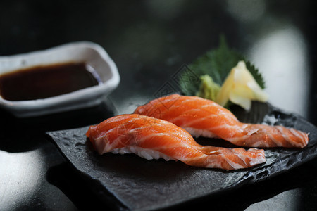 黑盘子上的三文鱼寿司图片