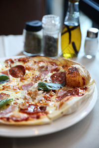 餐饮背景的辣椒尼培根和火腿披萨图片